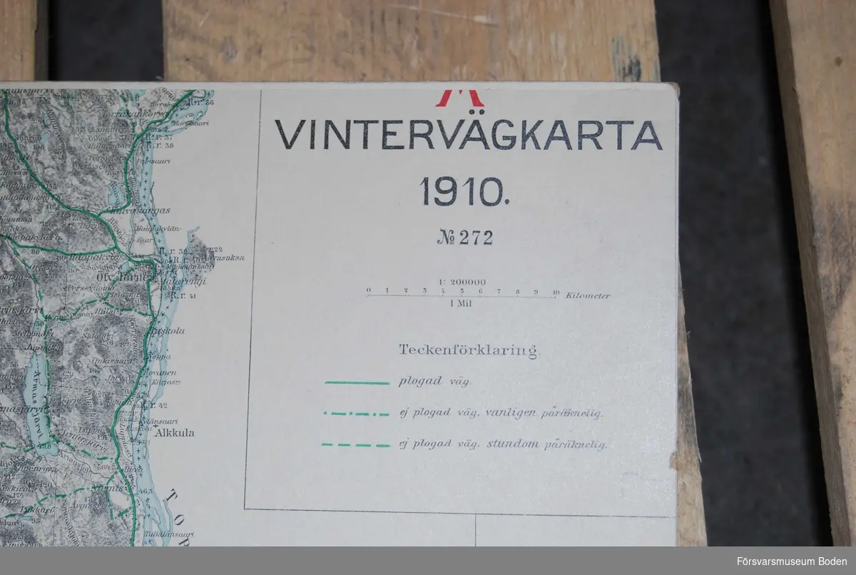 Trälåda innehållande kartblad på styv kartong i skala 1:10000, översiktskartor över sydöstra Norrbotten, vintervägkartor samt spelpjäser. Ska också innehålla bilagshäften, vilka saknas.