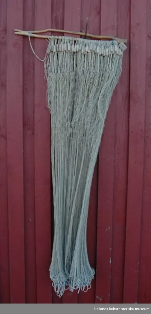 Fisknät med flöten av kork på splett av trä. 50 mm stolpe.