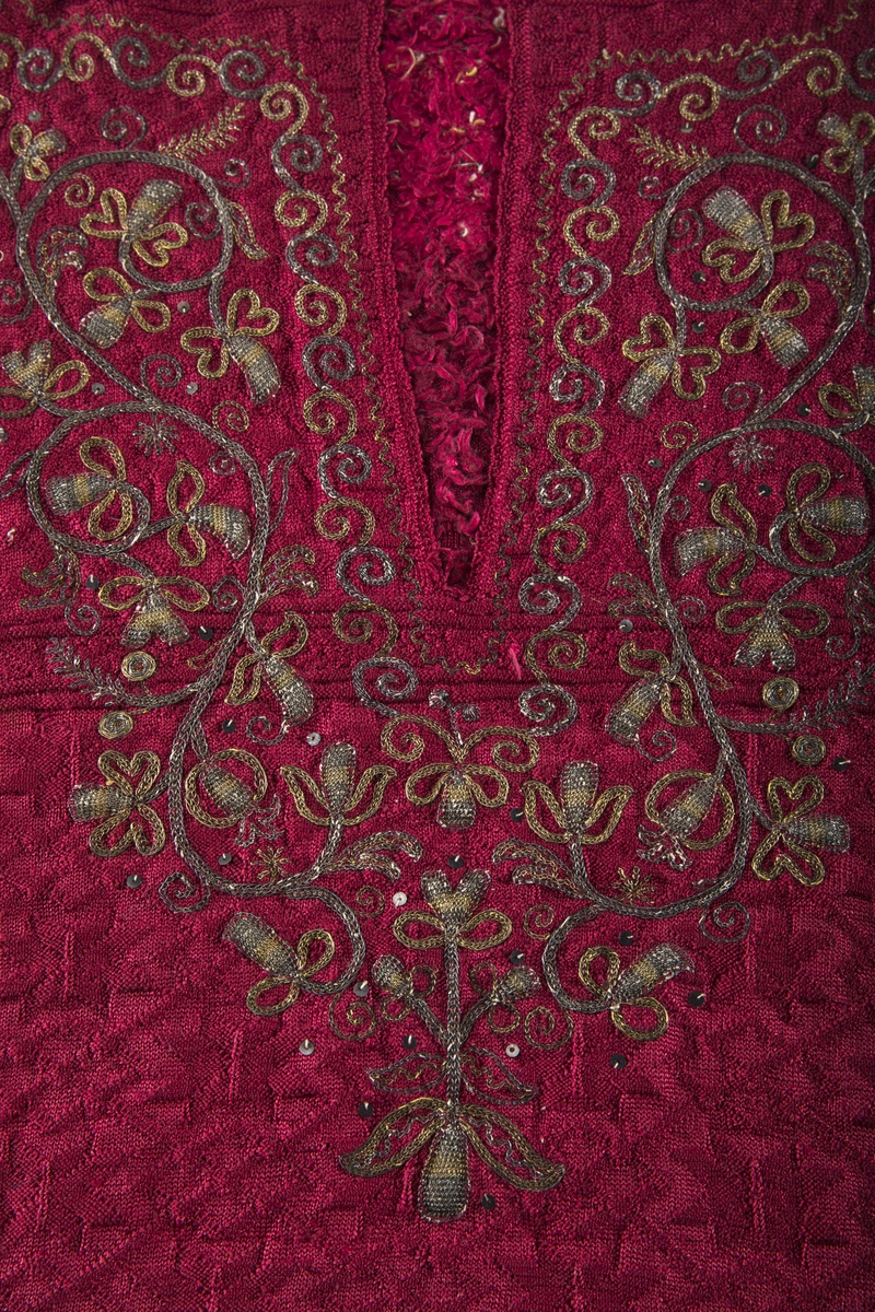 Mønsterstrikket rød nattrøye i silke med floss på innsiden og dekor av metallbroderi.