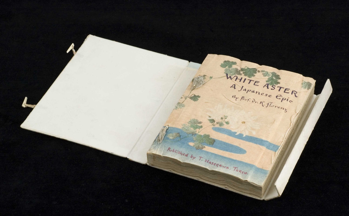 Bok av foldet, uskåret kreppapir med trykket tekst og tresnittillustrasjoner. Boken har original omslagskassett og er lagt i en boks av nyere dato.
