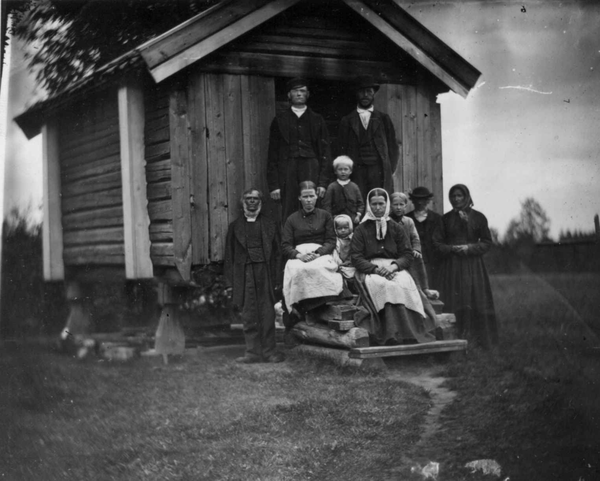 Arbeidsfolk, Dal gård, Ullensaker. Gruppe poserer på trapp foran uthus.
Fra portrettserie av personer som bodde på eller besøkte Dal gård, Ullensaker, fotografert av gårdens eier, kammerherre Fredrik Emil Faye (1844-1903) i årene 1875-1900.