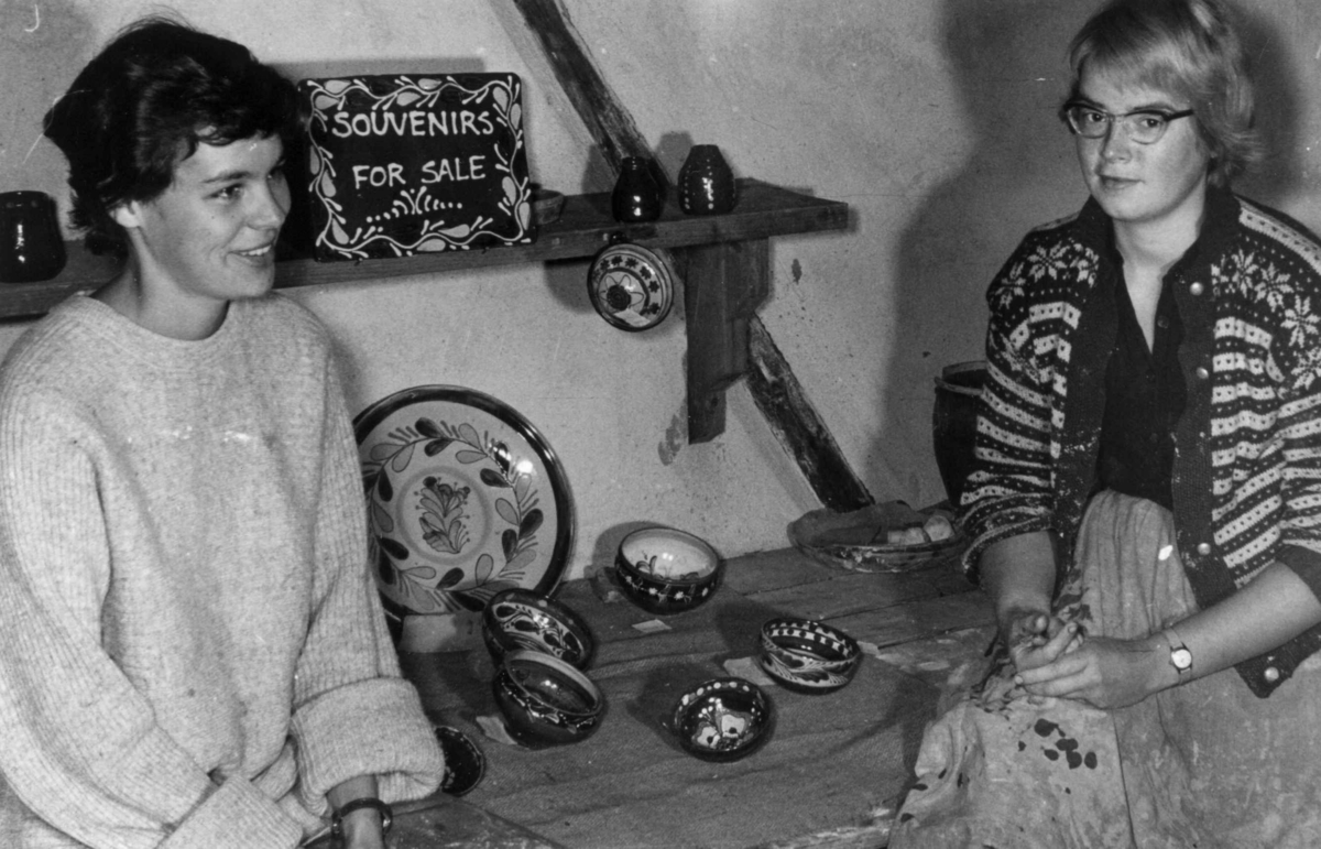 To kvinnelige keramikere viser fram gjenstander på pottemakeriet.