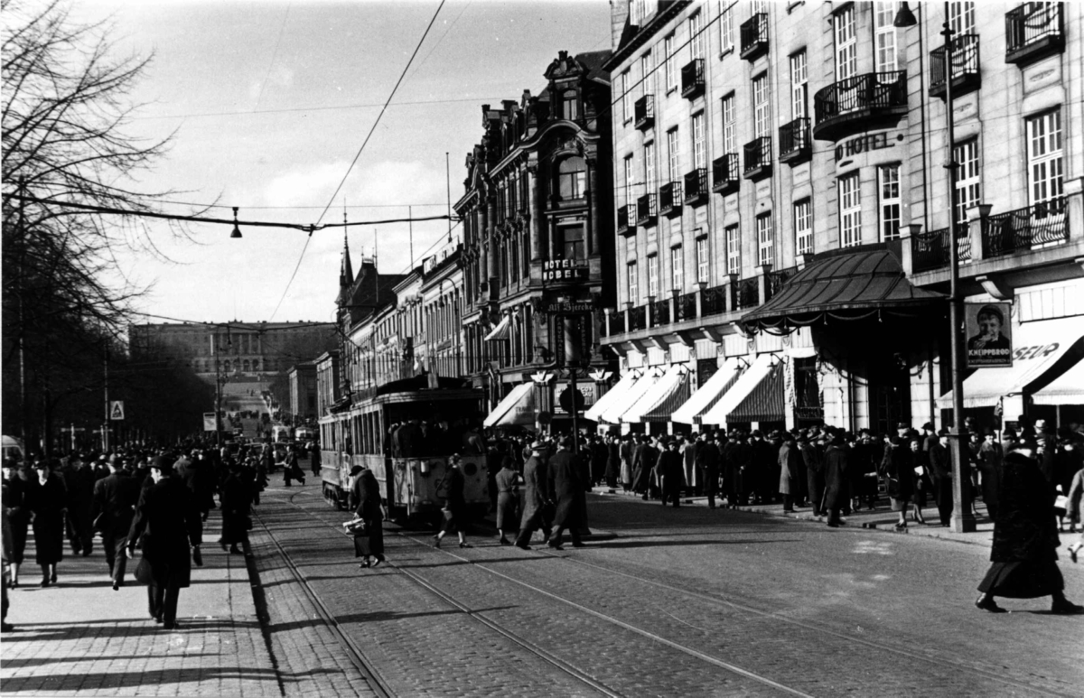 Karl Johans gate, Oslo 1938. gatebilde med mennesker og trikk foran Grand Hotell.