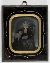 Portrett av kvinne, ukjent. Hun sitter i stol med bord som s