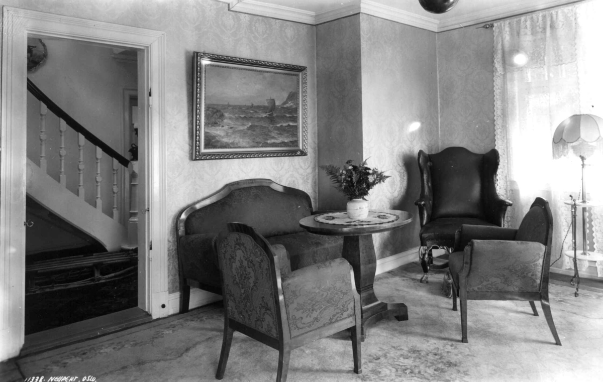 Roald Amundsens hjem, Svartskog. 1935. Interiør.
Stue. Stoler og bord. Maleri. Utsikt til trappeoppgang gjennom åpen dør til venstre.