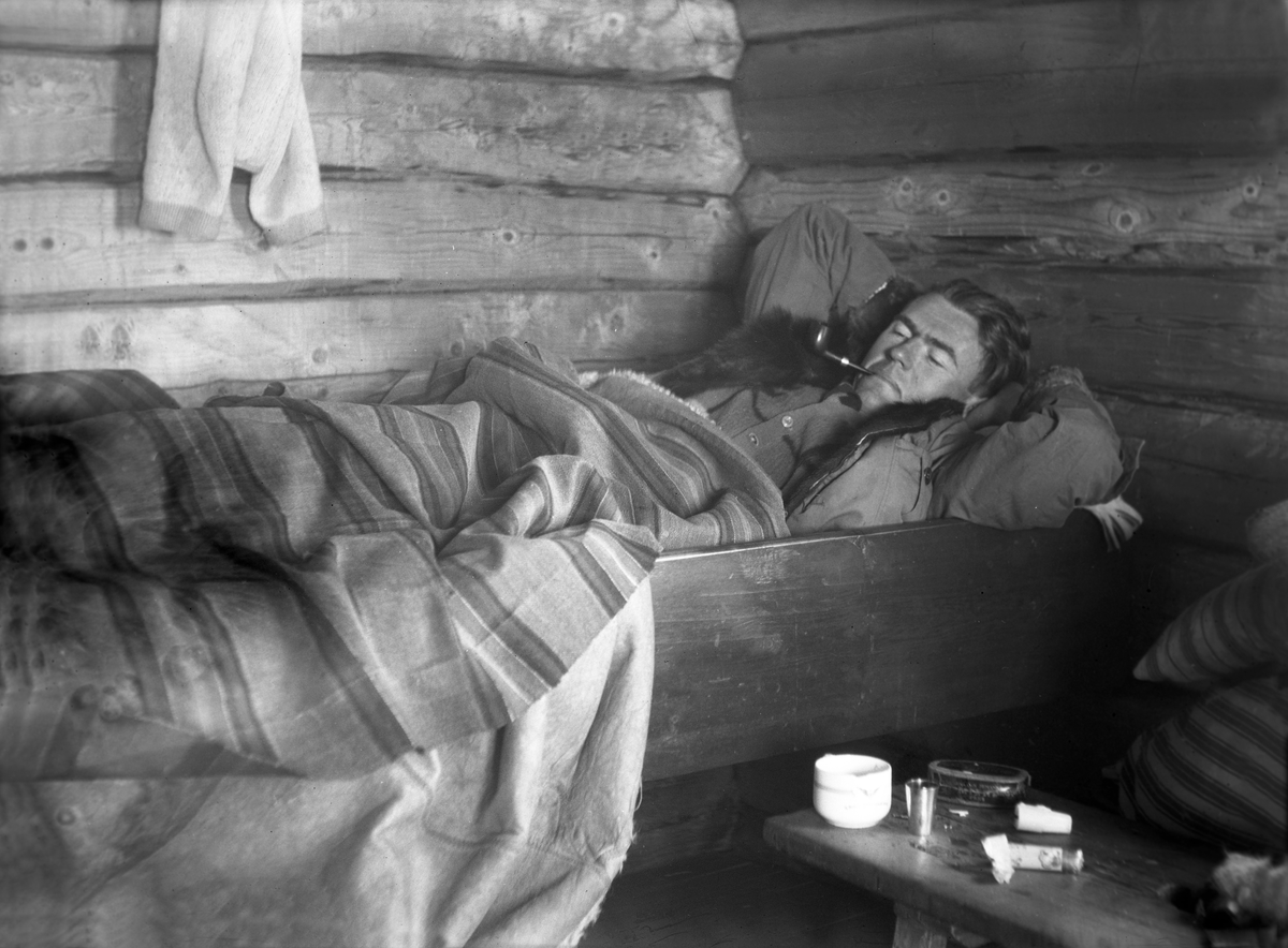 Bernt Jebsen ligger i senga i en av husene på Trøan. Fotografert påsken 1929.