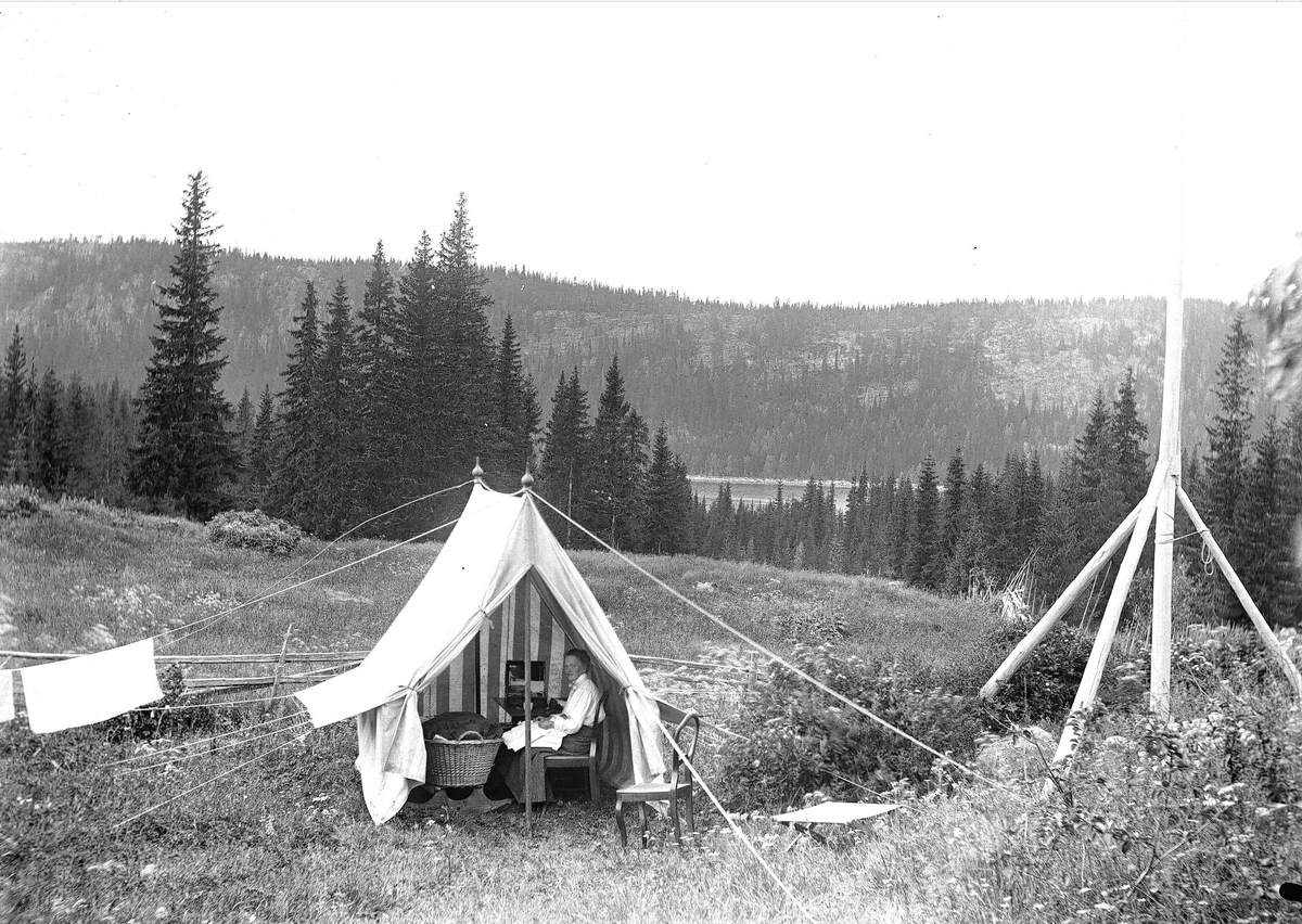 Holoa seter, Hadeland, Jevnaker, Oppland, 1903. Kvinne sitter i telt med kurv.