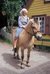 Kvinne i drakt ridende på hesten Tordis på Enerhaugen, Norsk