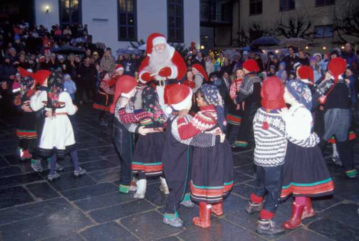 Julemarked på Norsk Folkemuseum året 2003. Museets dansegruppe opptrer på torget. Her sammen med julenissen.