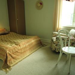 Seng med sengeteppe, stol og skap i herskapshus, Frogner. Il