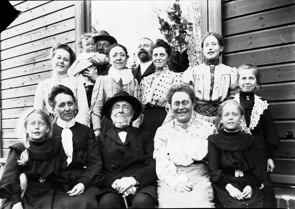 Familieportrett, stor gruppe mennesker foran bygning.
Familien Friis/Lund, ca 1902.
Se NF.28015-010 og NF.28016-010- og 023, samme motiv.