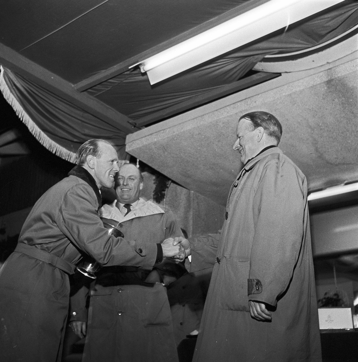 Serie. Skiløperen Håkon Brusveen under NM. Kong Olav er til stede ved premieoverrekkelsen.  Fotografert 1957.