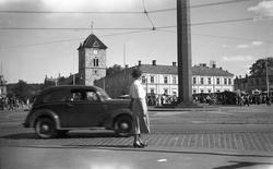 Dordi Arentz skuer ut over torget i Trondheim. I bakgrunnen 