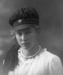 Portrett, jente med studentlue. Student frøken Helga Myhre.