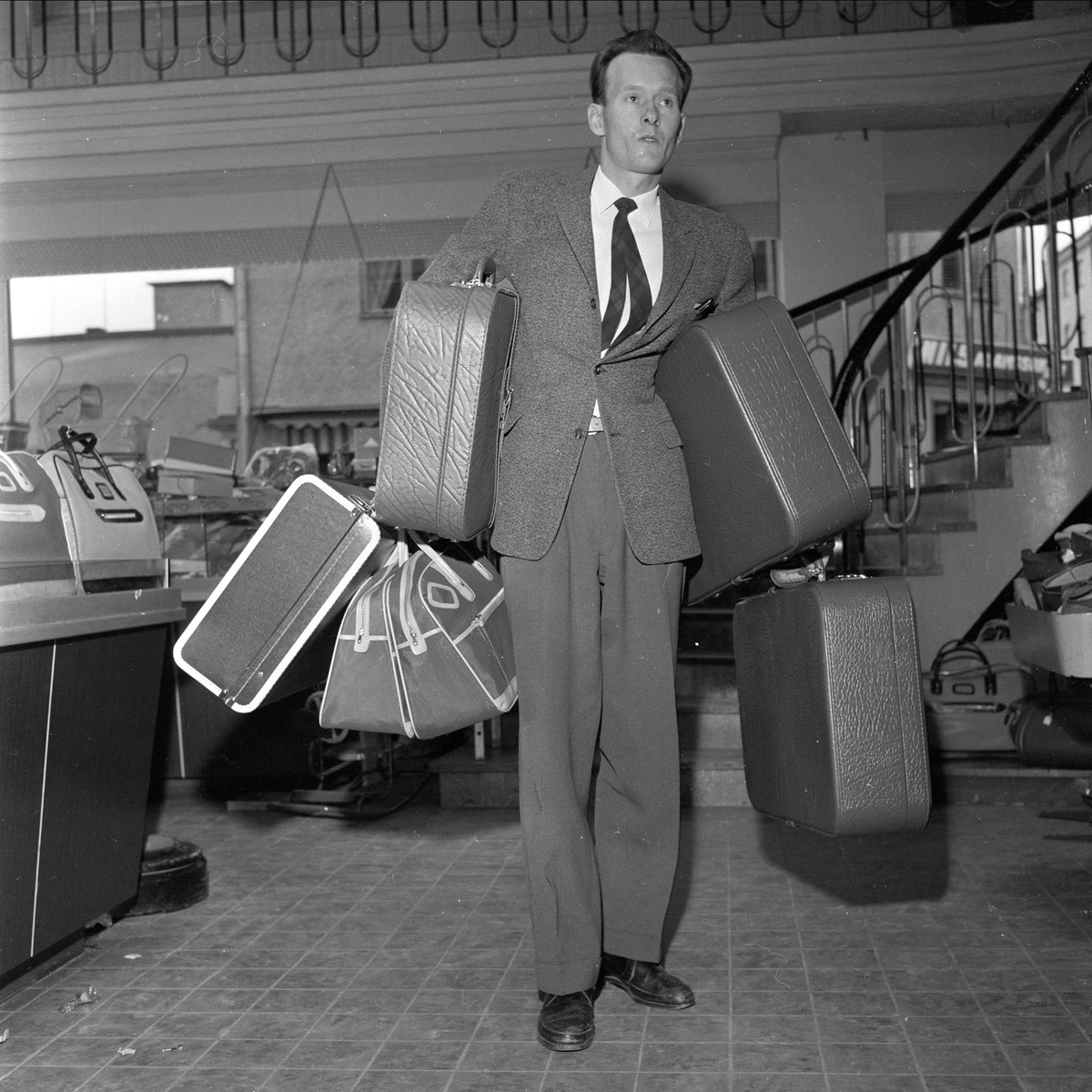 Juleinnkjøp i Arvika, grensehandel, Arvika, Sverige, 14.11.1959. Mann bærer kofferter.