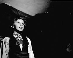 Bygdelag 29.03.1954. Kvinne med bunad på scene.