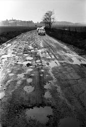 Riksvei 1 fra Svinesund, mai 1963. Landskap med sølete vei o