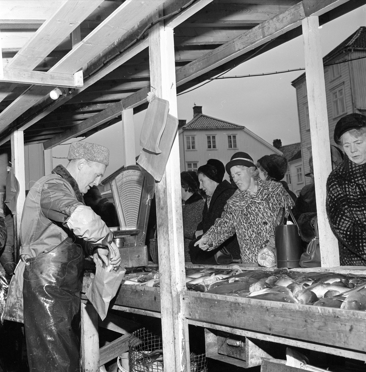 Arendal. Salg av fisk på Fiskebryggen, Tyholmen. Før 1964 salg fra åpne boder. Kvinner handler.