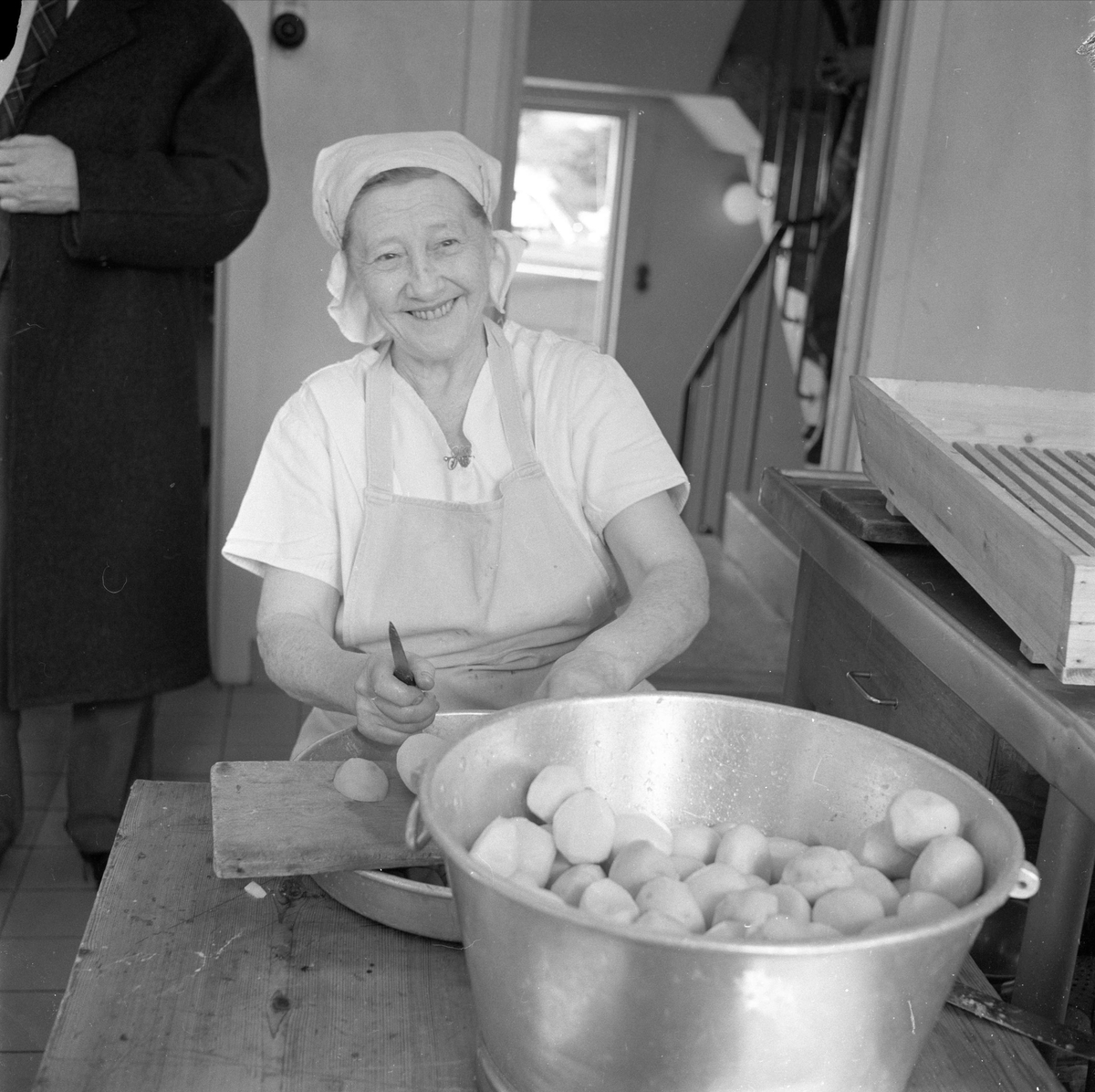 Elverum, 05.04.1960. 20 år etter 9.april 1940. Kvinne skreller poteter.
