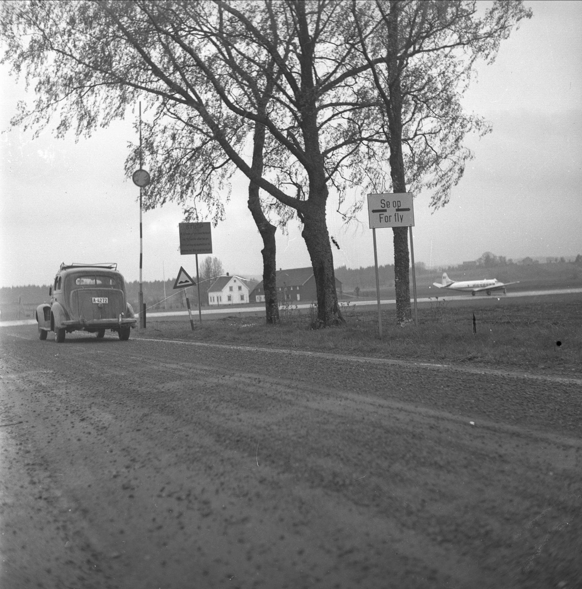 Jarlsberg flyplass, nå Tønsberg flyklubb, Sem, Vestfold, mai 1954. Bilvei langs flyplassen.