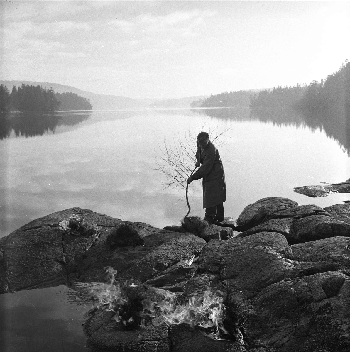 Kråkstad kommune, Ski, Akershus, 03.11.1956. Mann ved tre, innsjø i bakgrunnen.