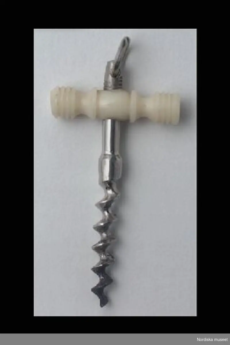 Inventering Sesam 1996-1999:
L  4,5  cm
Korkskruv, leksak, av stål, handtag av svarvat ben, upptill en ögla.
Birgitta Martinius 1997