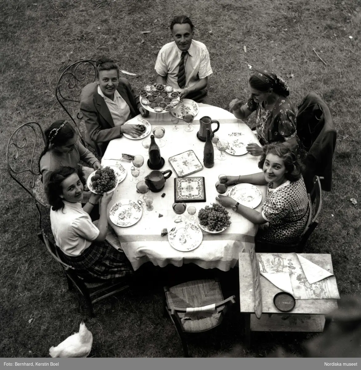 Journalisten Ingrid af Ström tillsammans med familjen Monnier samlade kring middagsbord utomhus. Frankrike.