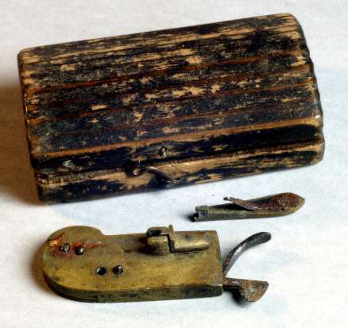 Rött träetui till ålderlåtningsredskap av mässing, med kniv av stål (UM08083b).
