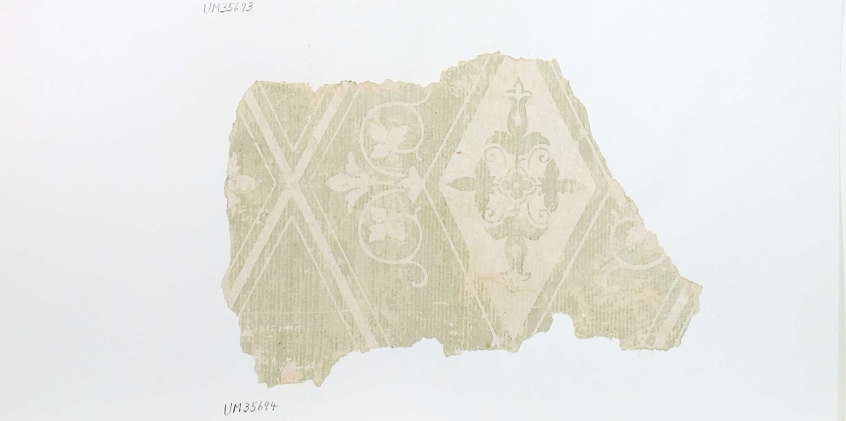 Tapetprov, vitt och ljusgrönt.
Text på baksidan av kartongen:
153
Kv. Kaniken
Trähuset
v. 1 tr Stora mittrummet