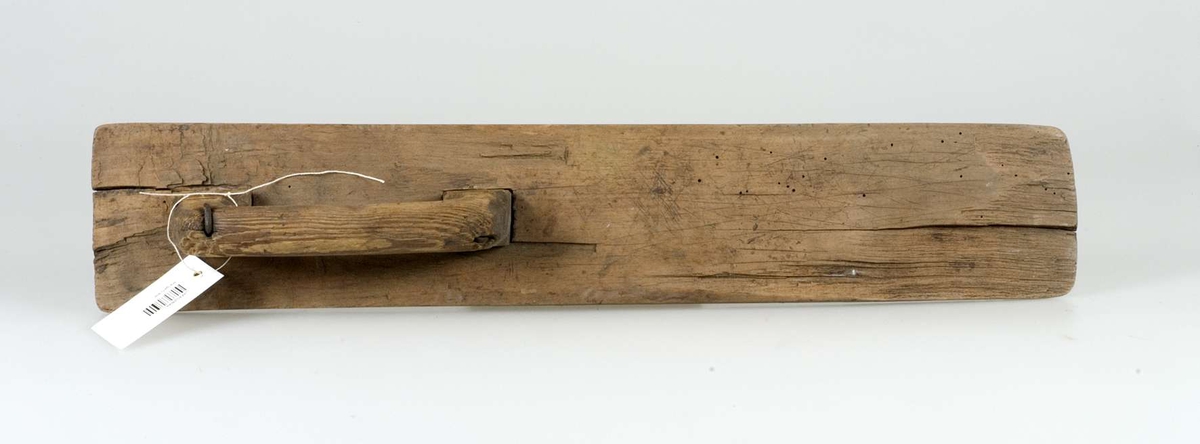 Mangelbräde av trä, odekorerat. Handtaget fäst med två spikar av järn.  Märkt E.C. No 1838  Alsike sn, Erlinghundra hd. Uppl.