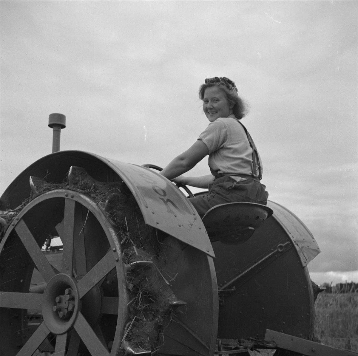 Ung kvinna på traktor på beredskapsläger i Skuttunge, Uppland 1940
