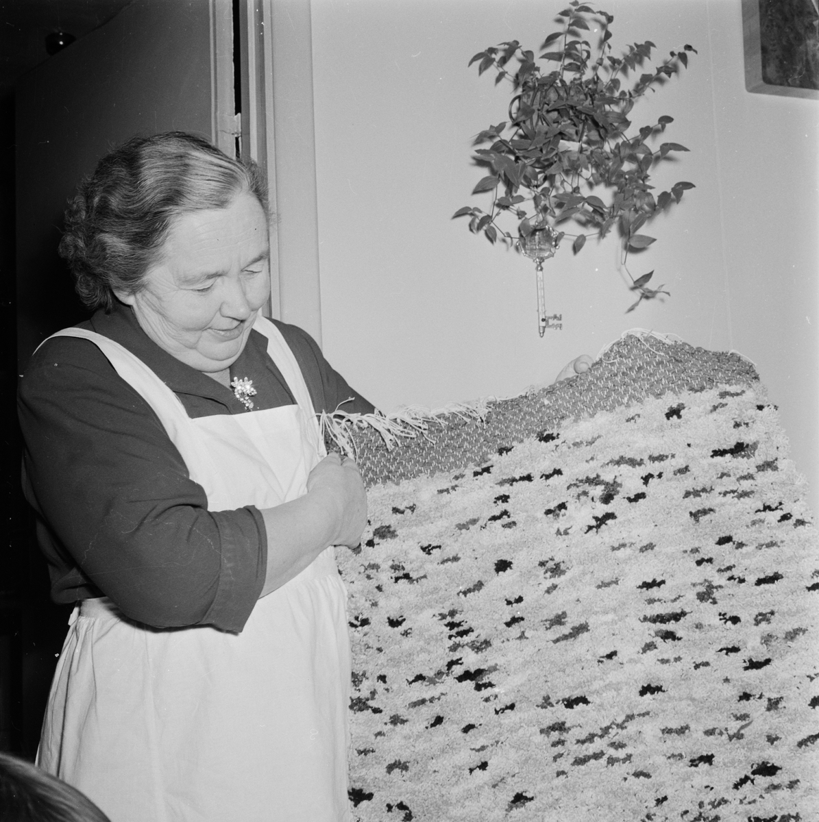 Lantbrukare Dina Eriksson, 1955 års mottagare av Insulanderska priset, med en matta hon vävt