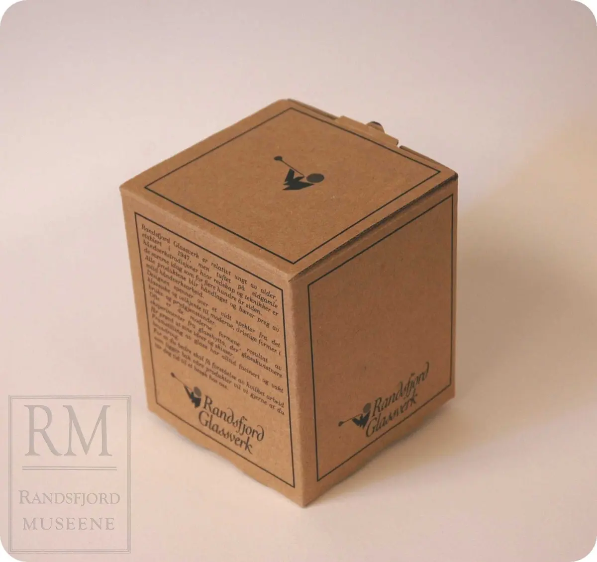 B: Emballasjen har motiv av en glassblåser på alle sider.