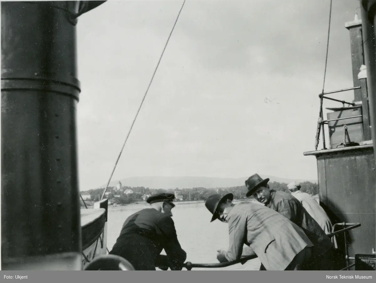 Fire menn på dekk på hvalfangstskipet D/S Hektor II (senere omdøpt til Norman I), B/N 458, under prøvetur i Oslofjorden. Skipet ble levert av Akers Mek. Verksted i 1930 til A/S Hektor, ved skipsreder N. Bugge, Tønsberg.