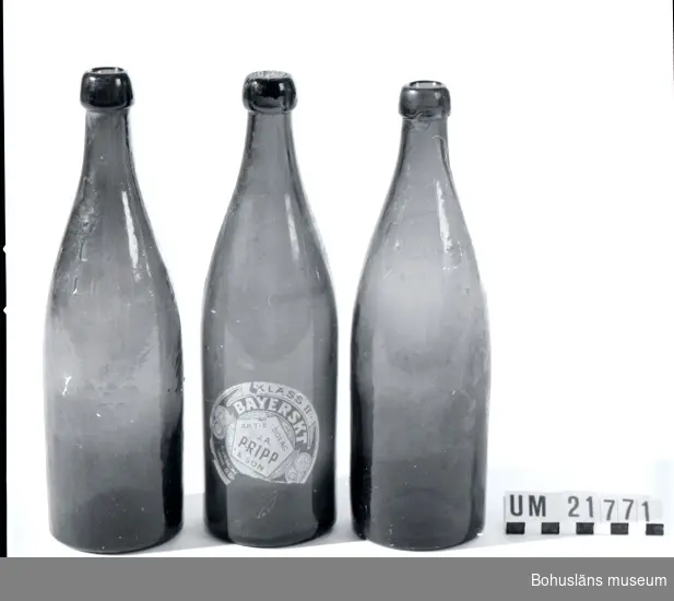 Del av kork sitter kvar i en flaska, liksom etikett på samma flaska. Brunt glas med fattning för naturkork.
Flaska nr 1  märkt: "L 2/3 Lit. 1900. 16". 
Flaska nr:2 märkt  L 2/3 Lit.1900.13. 
Flaska nr: 3 märkt  L* F.