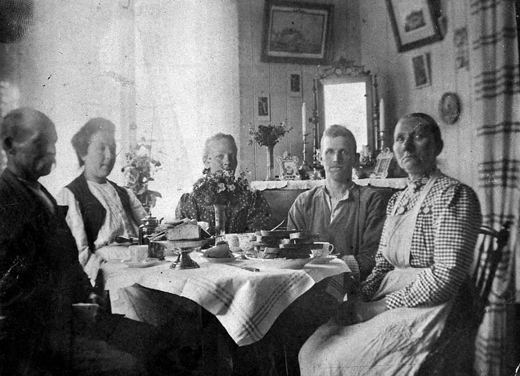Enl. tidigare noteringar: "Simon Anderssons familj runt kaffebord. "Familjen på Koö". 
Repro 1985 av fotografi tillhörande Gustav Rundberg, Bovallstrand".