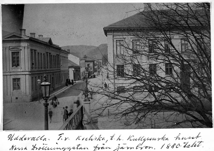 Text på kortet: "Uddevalla. T.v. Kochska, t.h. Kullgrenska huset, Norra Drottninggatan från järnbron. 1880-talet".