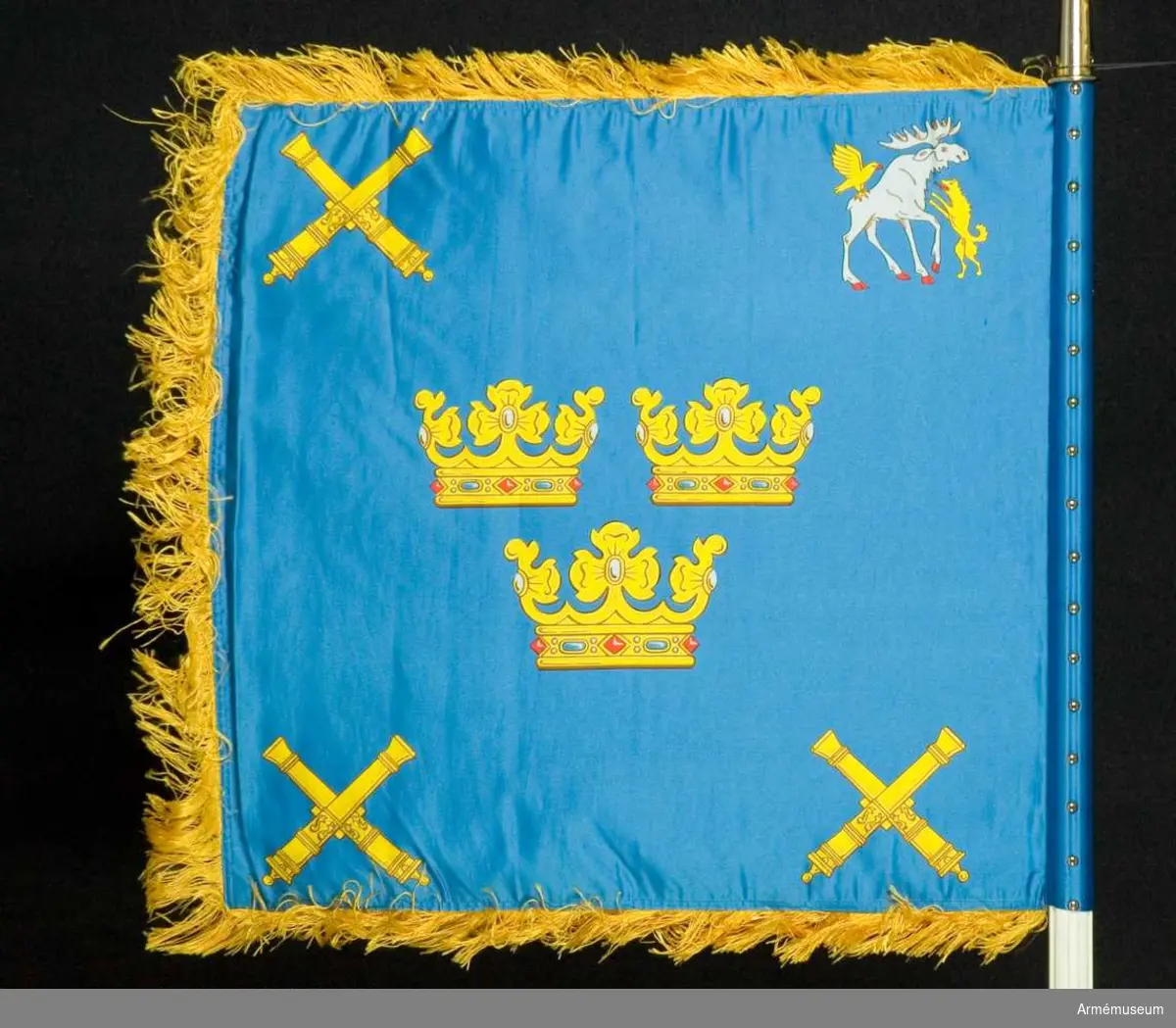 Text på doppsko: "Vaktstandar tillverkad 1986
Kungliga Norrlands Artilleriregemente 16 juni 1938 Gustav V"

