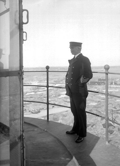 Mars 1924. Fyrmästaren Uhrberg stående på lanterninbryggan på Hållö fyr.
