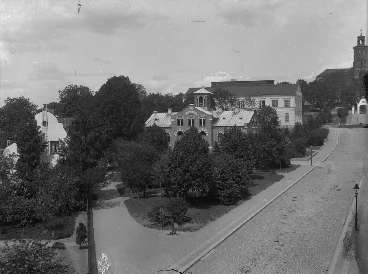 Trekanten (Afzelii plan) och Kyrkogatan, Enköping, vy från söder, ca 1915. Fr. v. prästgården, tingshuset, realskolan (läroverket), kyrkbacken, kyrkan.