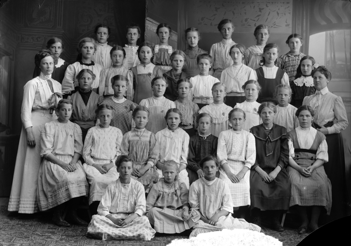 Skolklass, flickor, oidentifierad. Anteckning på skyddspapper "Fru Wallins grupp 1911".