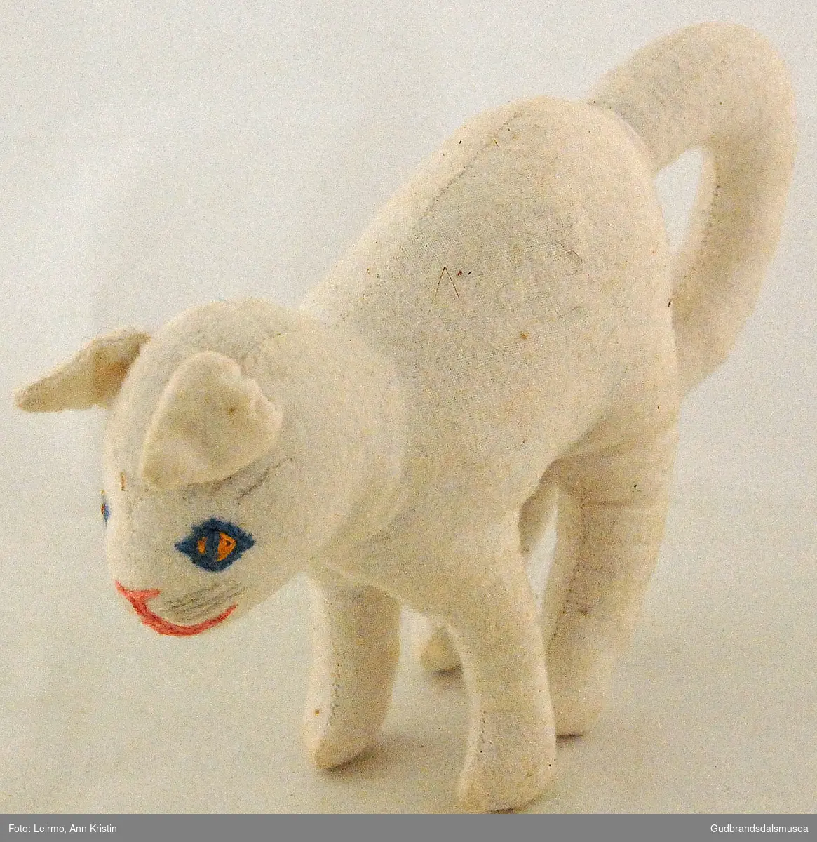 Hjemmelaget lekedyr av bomullstøy. Hvit katt, med påbrodert munn, snute, værhår og øyne. 