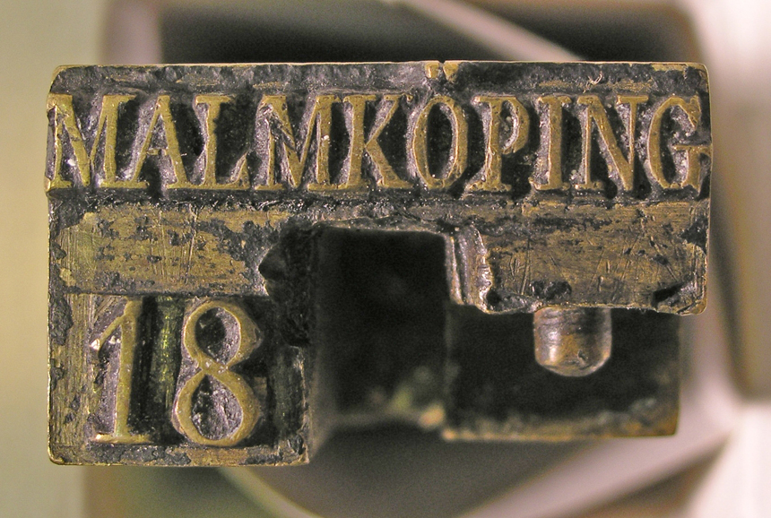 Datumstämpel, linjär i antikvastil utan ram, texten"Malmköping 18--". Normalstämpel 4 enligt stämpelhandboken, 1952.