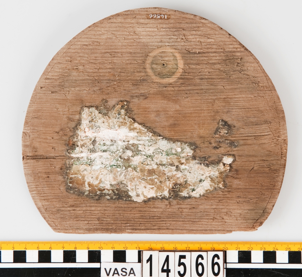 Botten till en bytta eller liten tunna. En del saknas. På föremålet finns vita klumpar som efter analys visats sig vara troliga rester av smör.