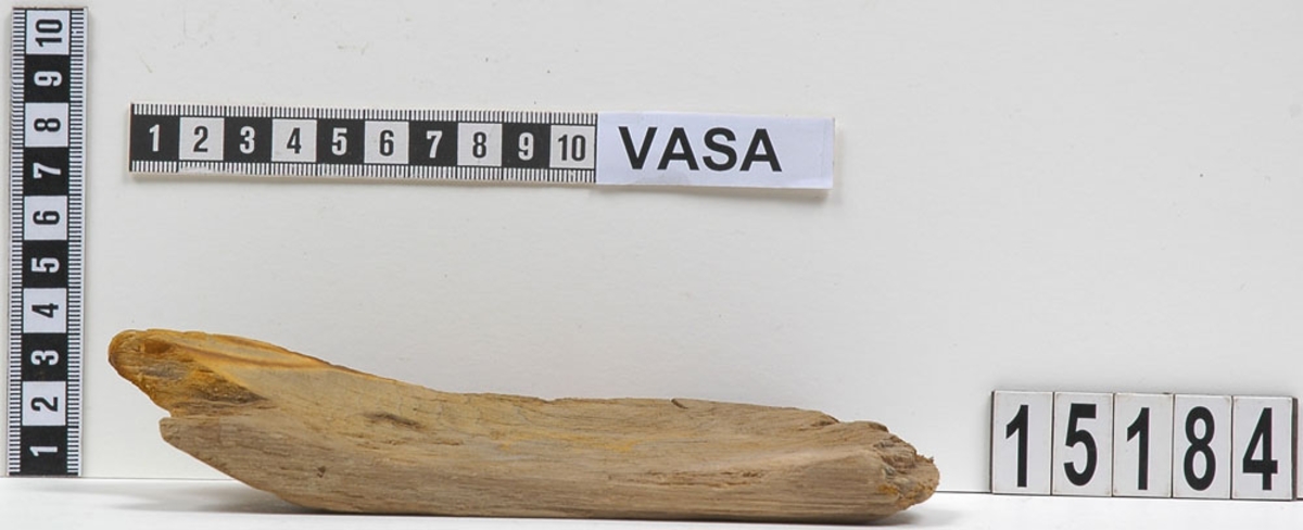 En del av en svarvad träskål. På baksidan syns ett inristat E.
Splittrad. Många skärmärken finns på skålens insida.