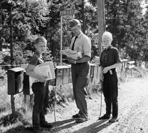 Bilåkande lantbrevbäraren Erik Johansson på linjen Åkersberga - Singö - Björnhuvud - Åkersberga. Lantbrevbärare Johansson lämnar post vid brevlådesamlingen i Alsvik.

Foton augusti 1961.