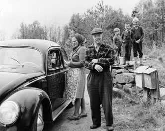 Greta Pettersson och Per Persson i Södra Havhult, får dagens post. Vikarierande bilåkande lantbrevbäraren Gert Stjernqvist, på linjen Lönsboda-Duvhult.

Foto maj 1961.