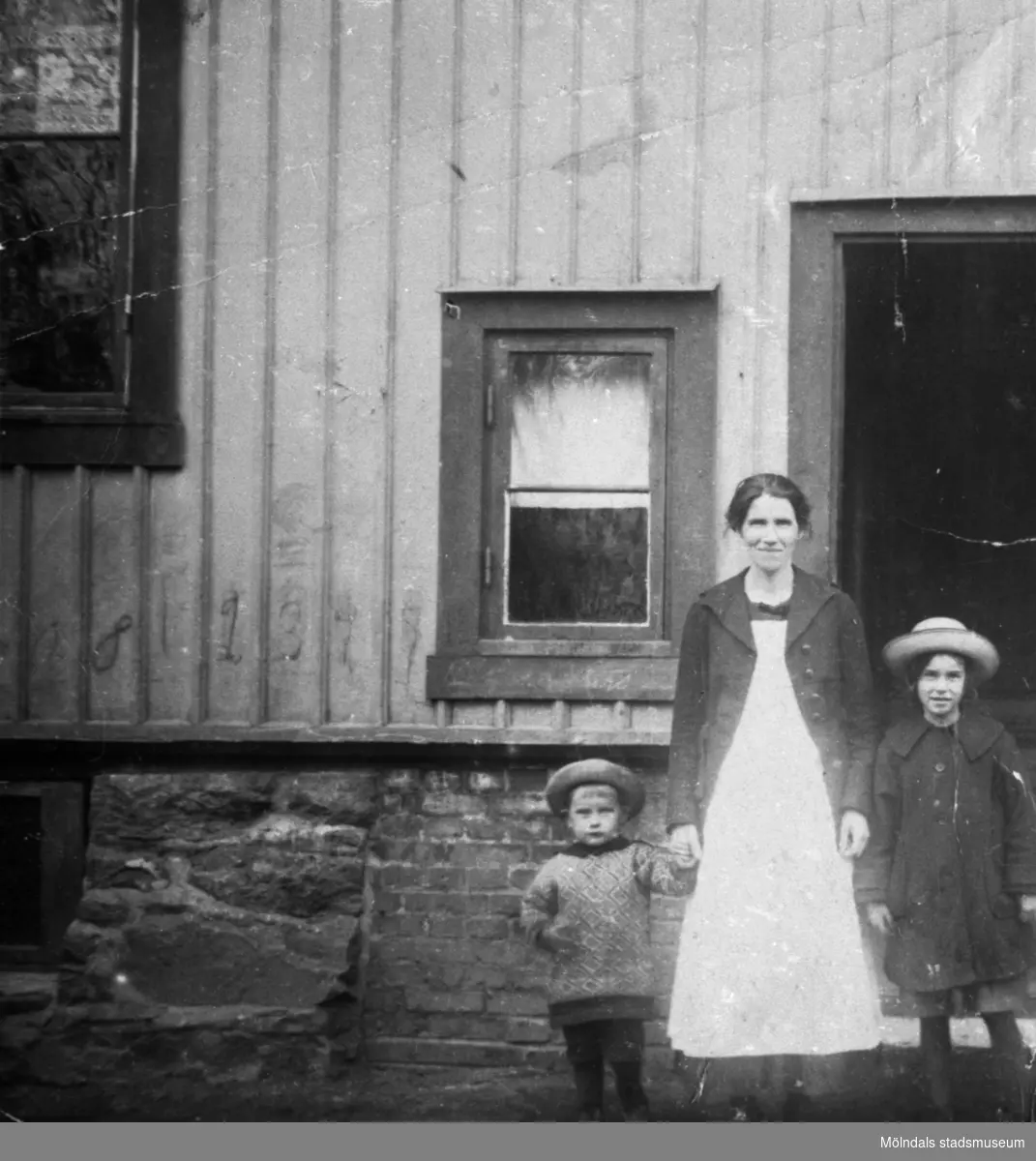 Givaren Knut Anderssons mor Olga samt de äldre syskonen Sara och Evald poserar utanför "Täppan" i Krokslätt. Ca 1921.