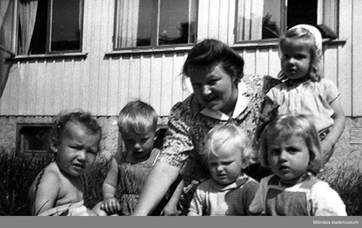 "Älsklingsbarnet" Håkan Carlsson och andra barn med en lärare på Krokslätts daghem, Dalhemsgatan 7 i Krokslätt. 
Under Margit Emilssons (gift Wannerberg -52) praktik som biträde
1945-10-01 - 1946-08-01. "Håkans charm och hans rara föräldrar bidrog till att jag valde yrket 'barnträdgårdslärarinna'. Jag var otröstlig när jag skildes från Håkan - då jag slutade för att börja på seminariet." / Margit Wannerberg.