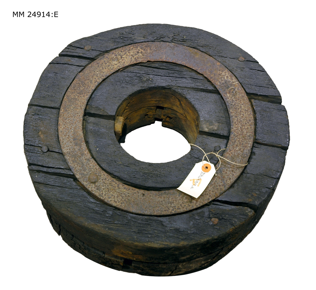 Svart hjul som består av flera hopsatta delar som hålls samman av en järnring. Hål i mitten för hjulaxeln.